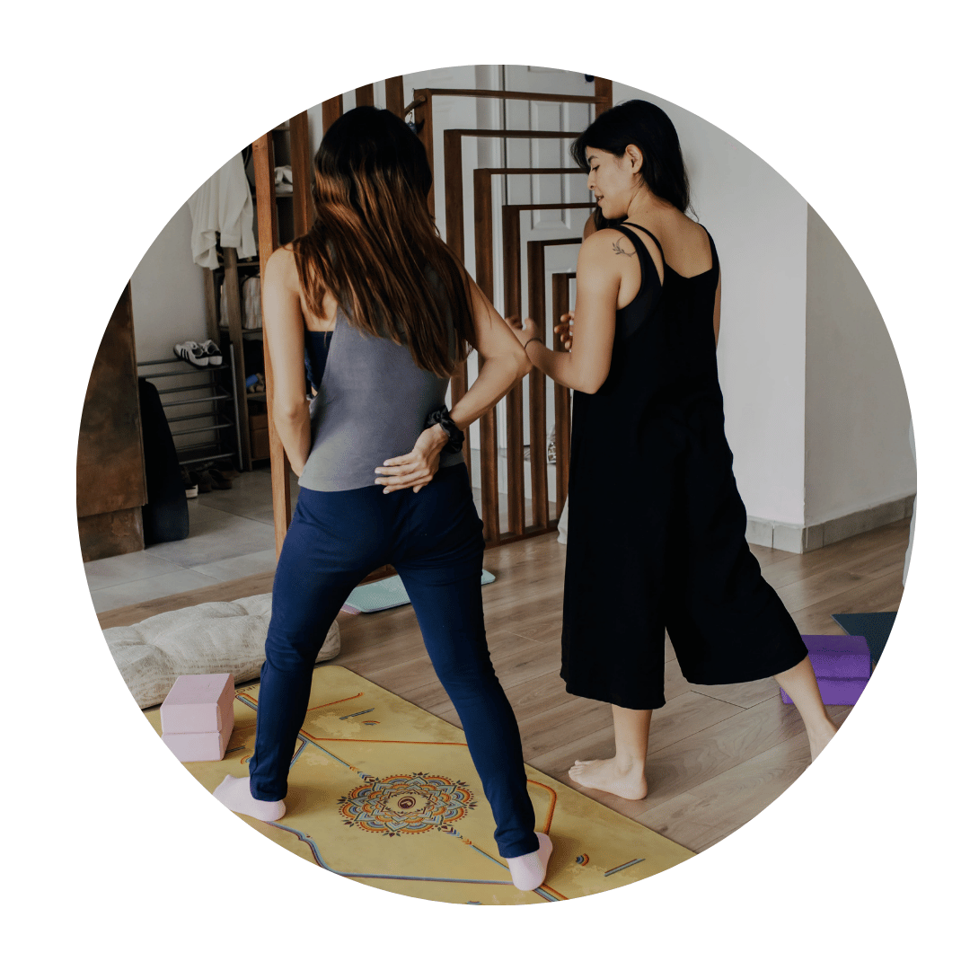 Doula Ale guiding a pregnant woman through a prenatal yoga stretch to prepare for labor.