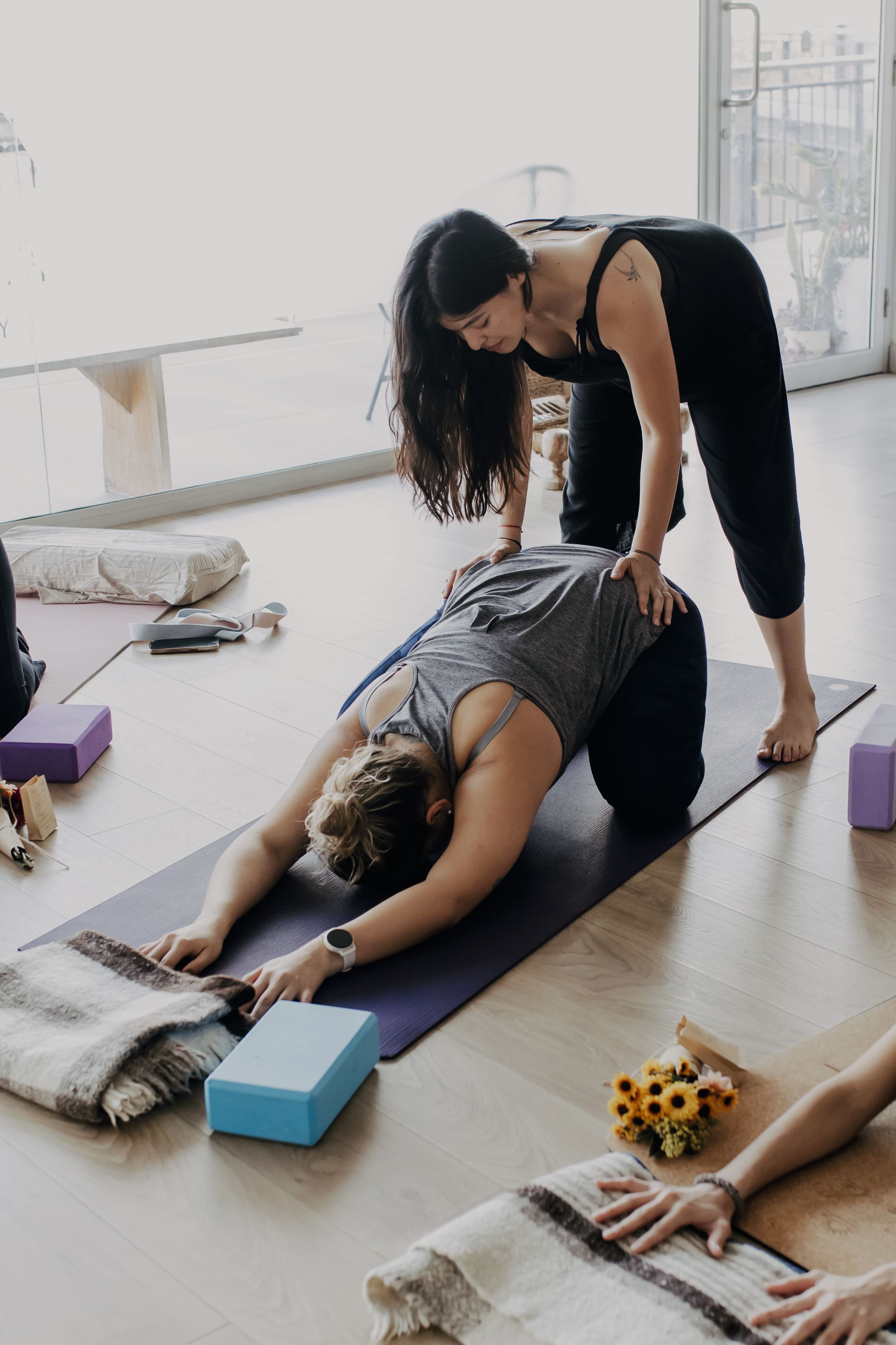 Montreal postpartum and birth doula Ale assisting a client with prenatal yoga poses.