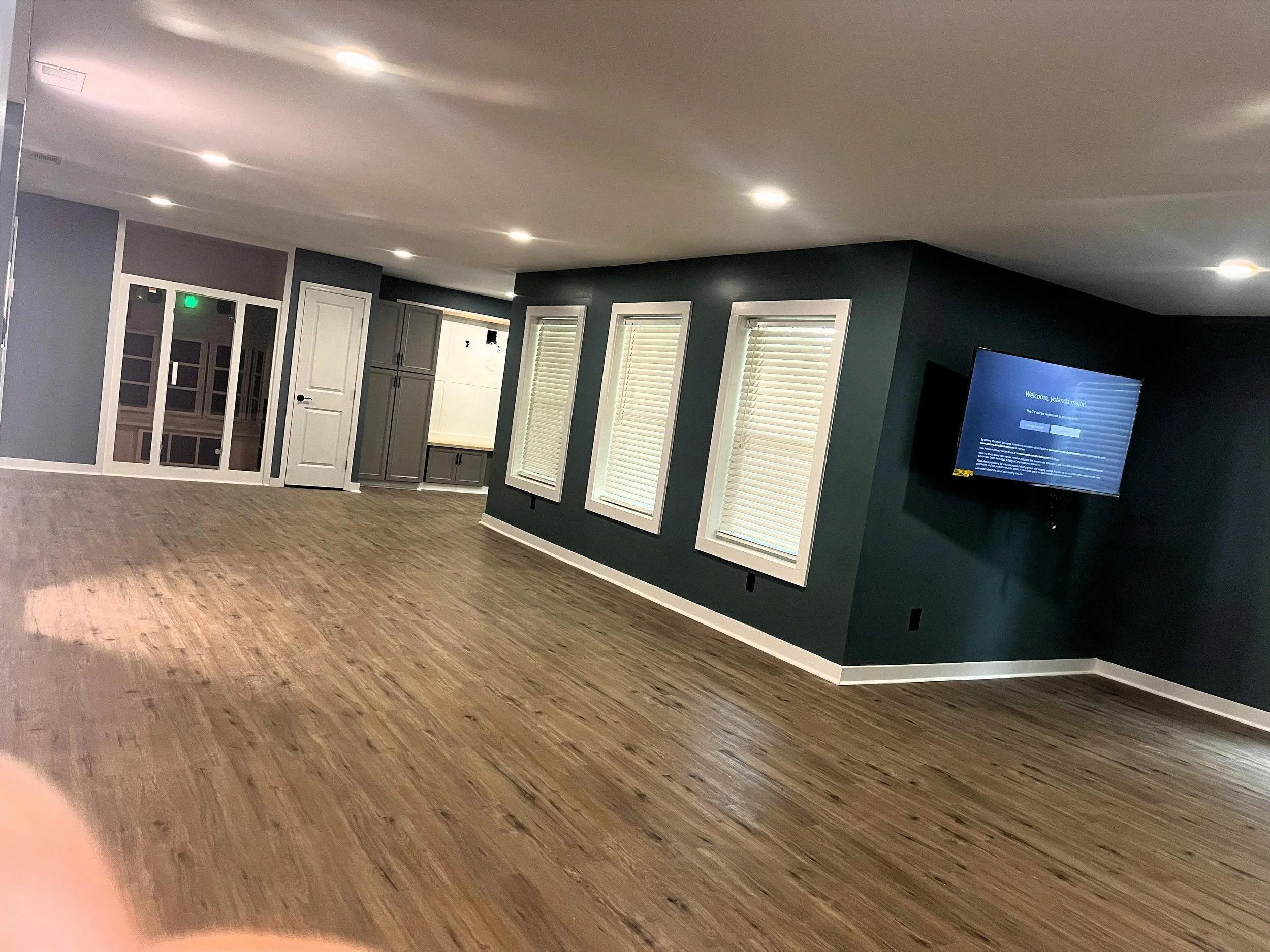 Modern finished basement with recessed lighting and hardwood floors