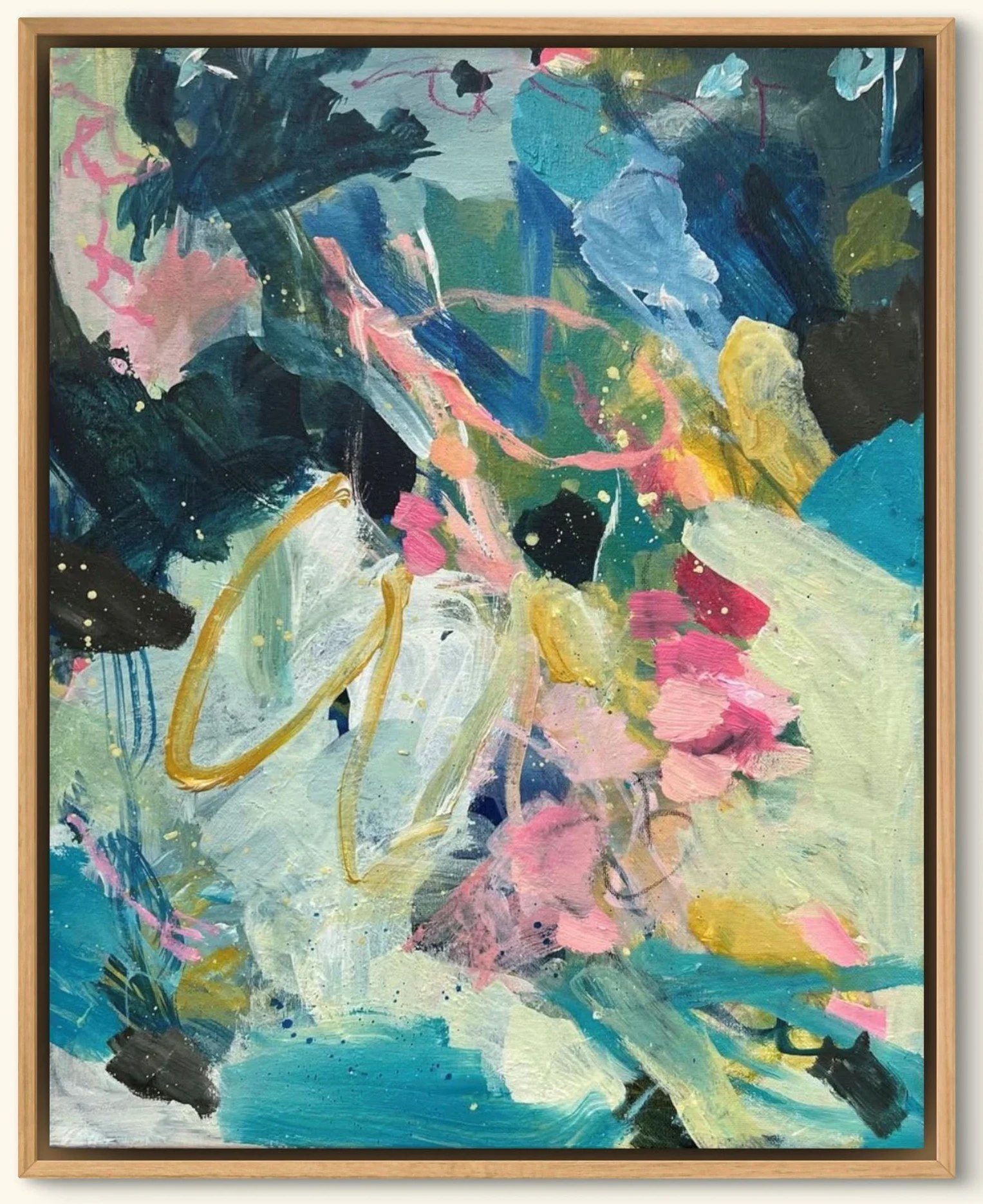 An abstract painting with bold brushstrokes and vibrant colors including pink, blue, green, black, and yellow, framed in a light wooden frame.