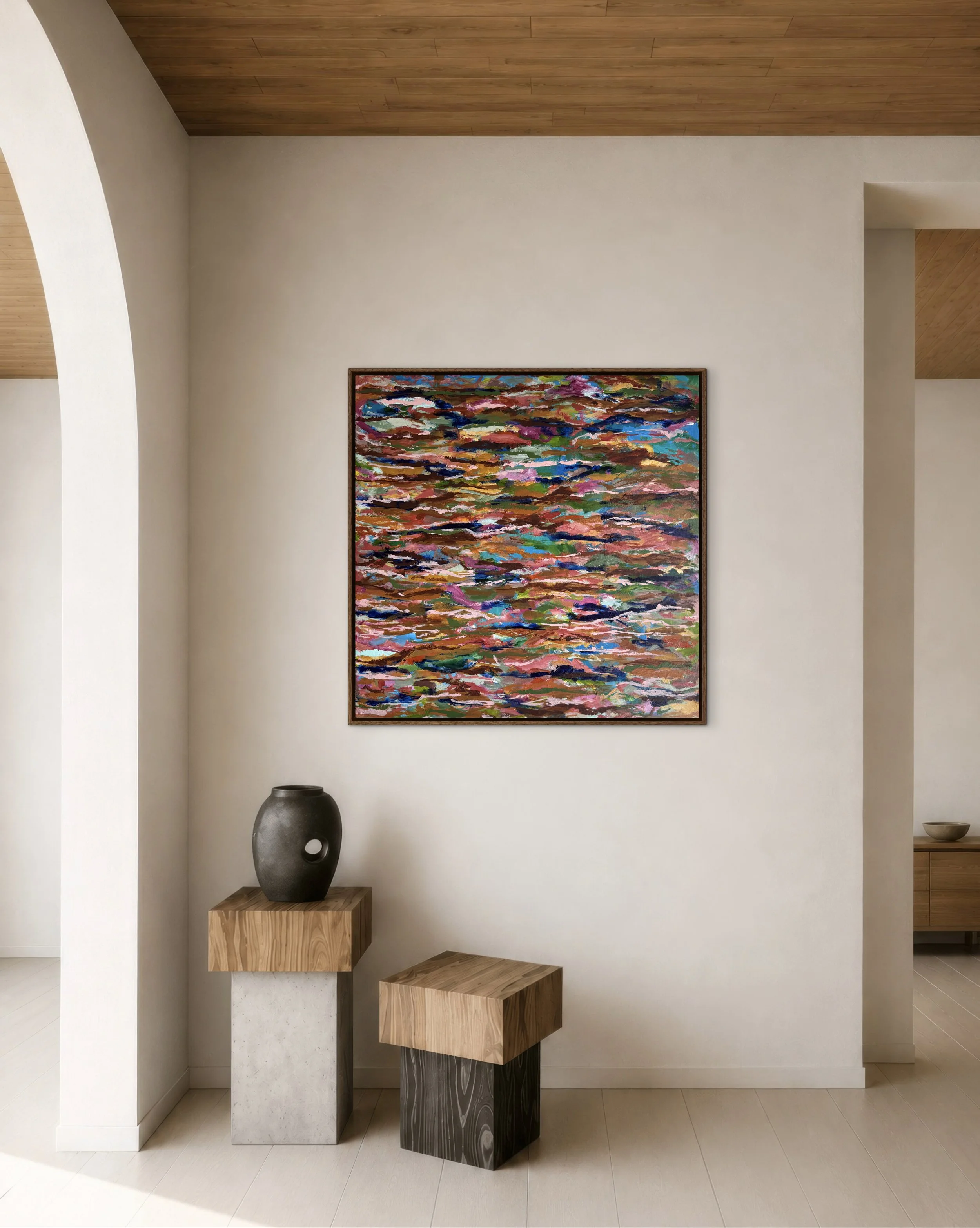A minimalistic interior with three ornamental pedestals of different heights made of stone and wood, arranged side by side against a white wall. A large, colorful abstract painting hangs on the wall above the pedestals. A black and gray vase sits on the left pedestal, and a small bowl rests on the right wall corner.