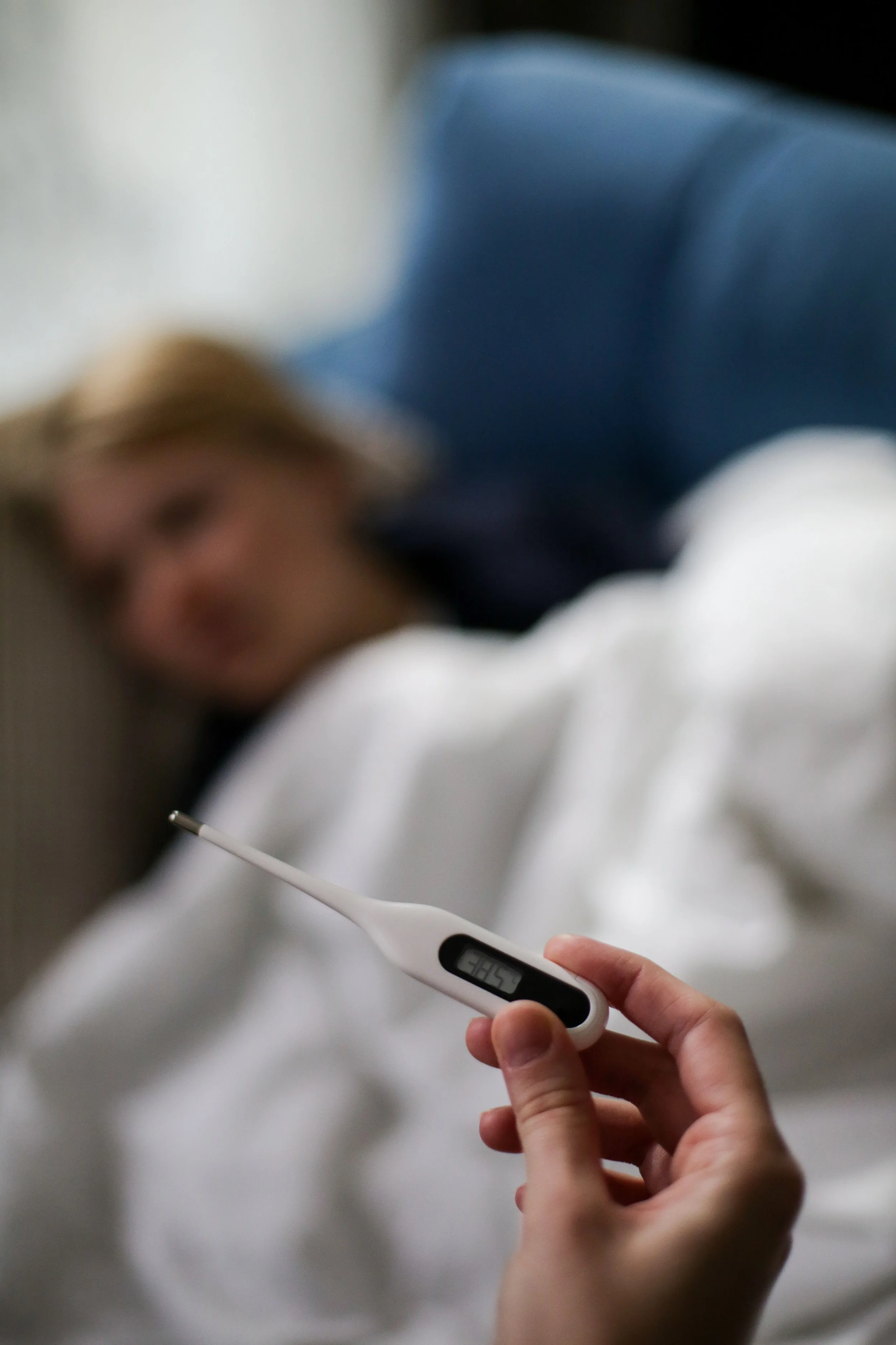 Thermometer with sick child behind