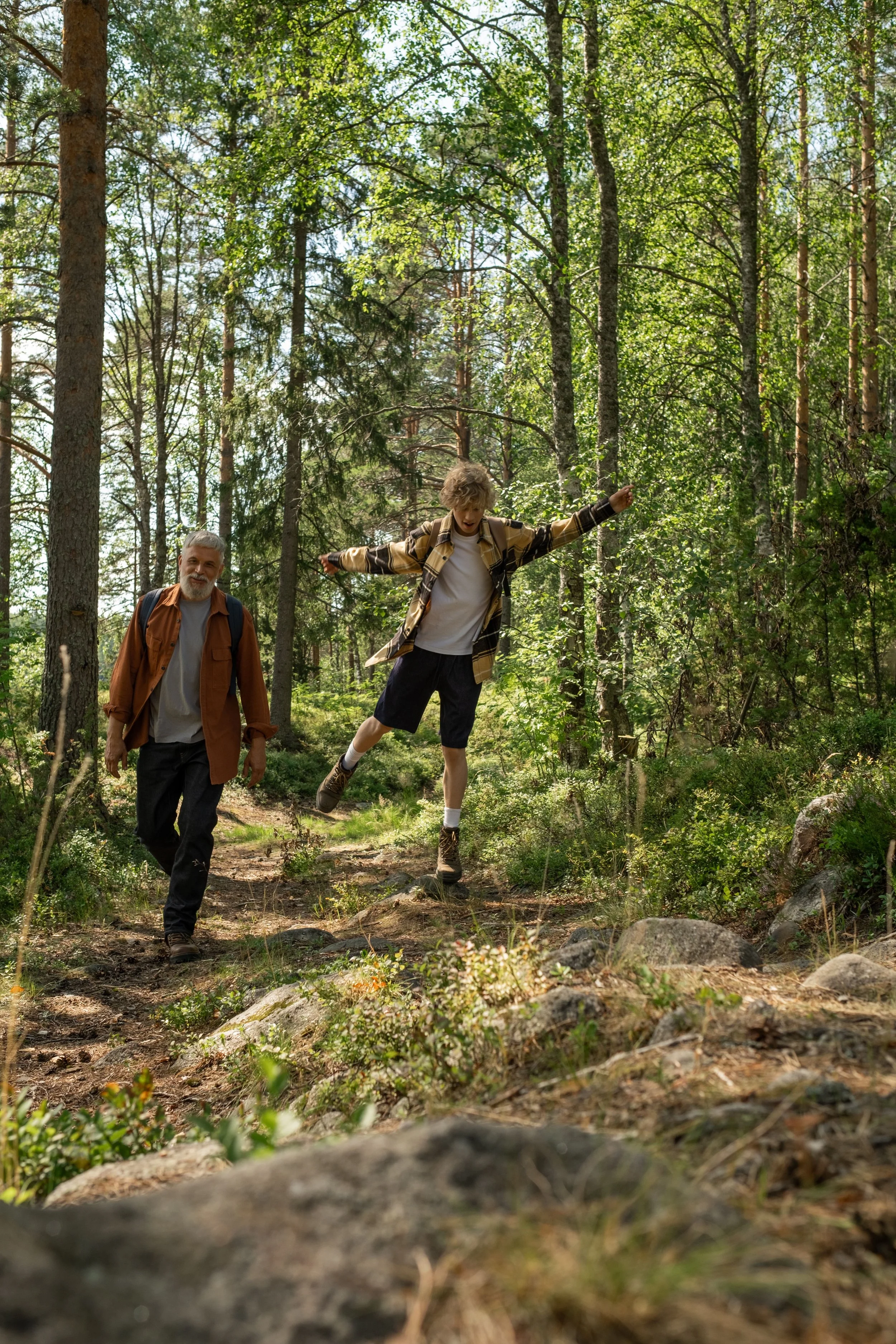 Dad and teen son hiking in a forest
