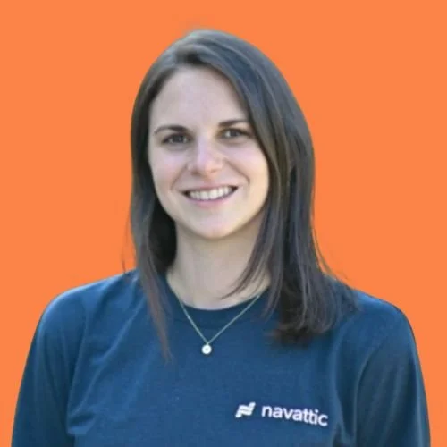 Natalie Marcotullio is wearing a navy blue Navattic t-shirt and a delicate necklace, against an orange background.