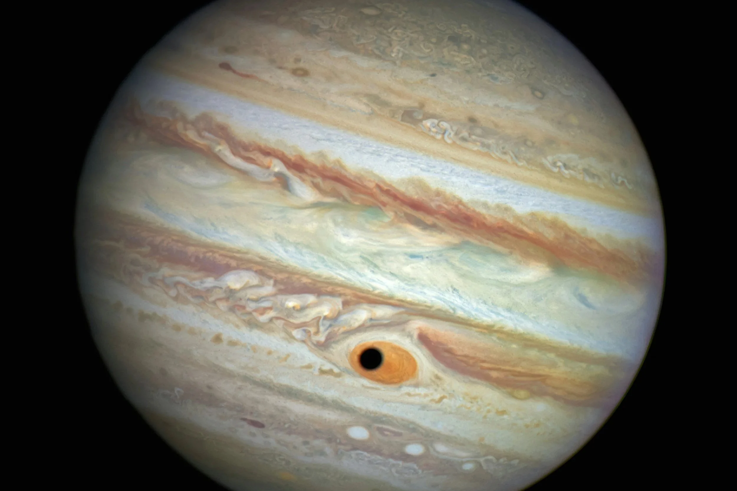Close-up view of Jupiter's surface showing bands of clouds, storms, and the Great Red Spot.