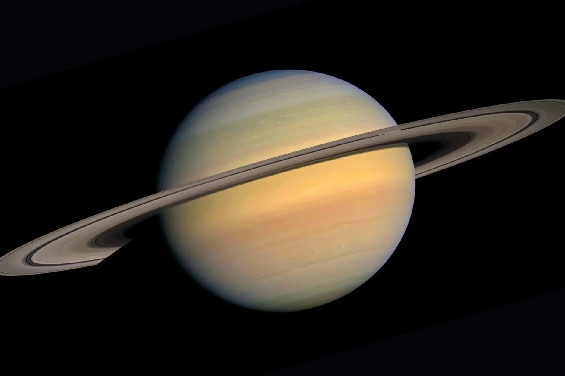 Image of Saturn highlighting its rings and planet's surface with bands of clouds.