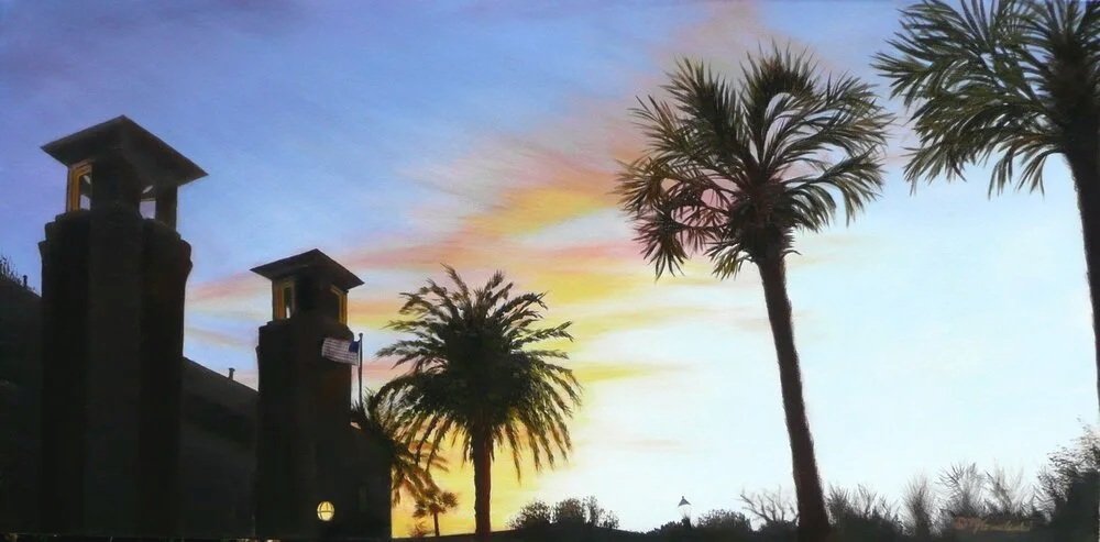 Sunset with colorful sky, palm trees, and two tall chimneys.