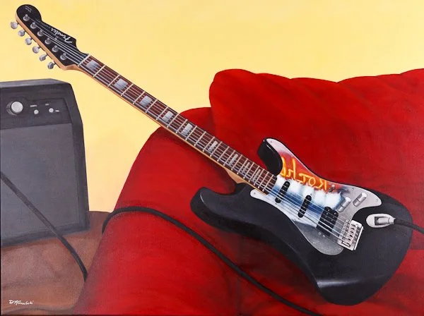 Electric guitar resting on a red sofa next to an amplifier.