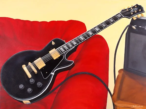 Electric guitar resting on a red sofa with an amplifier nearby.