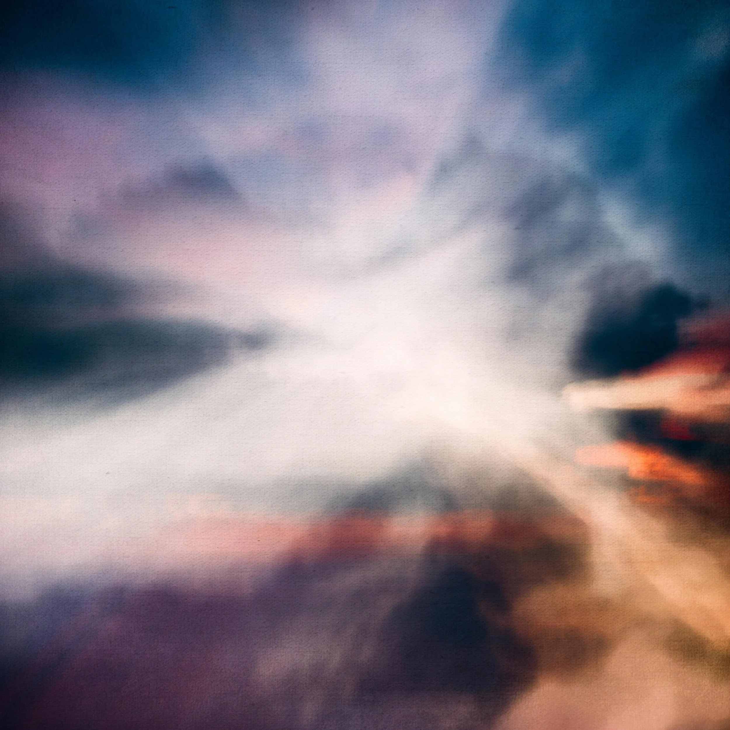 Colorful sky with clouds during sunset or sunrise, featuring shades of blue, pink, purple, and orange.