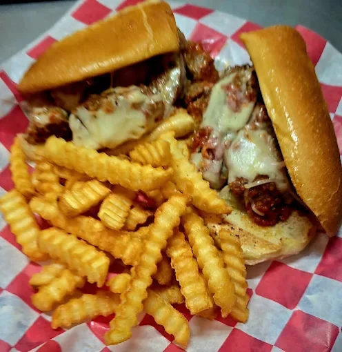 Cheeseburgers with crinkle-cut French fries on red and white checkered paper.