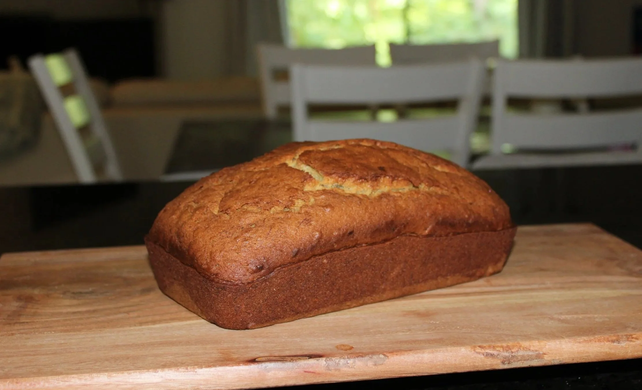 Freshly baked banana bread loaf with a golden-brown crust and soft, moist interior, perfect for breakfast, snacking, or dessert.