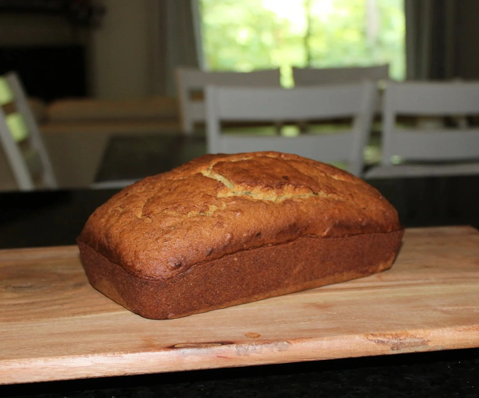 Freshly baked banana bread loaf with a golden-brown crust and soft, moist interior, perfect for breakfast, snacking, or dessert.