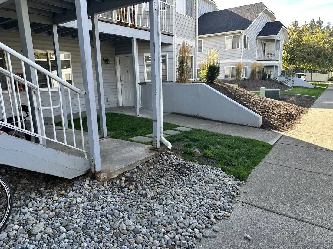 Existing stair landing at Trail Lodge Apartments, with loose stone and small paving surfaces between the stairs and the main sidewalk.