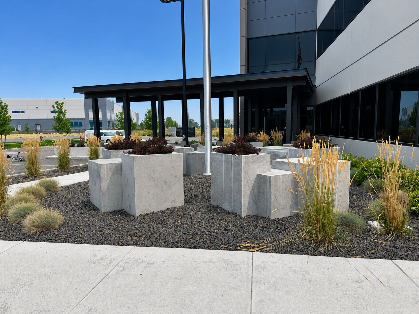 Raised concrete planters and ornamental grasses at the Wildfire Defense building entrance