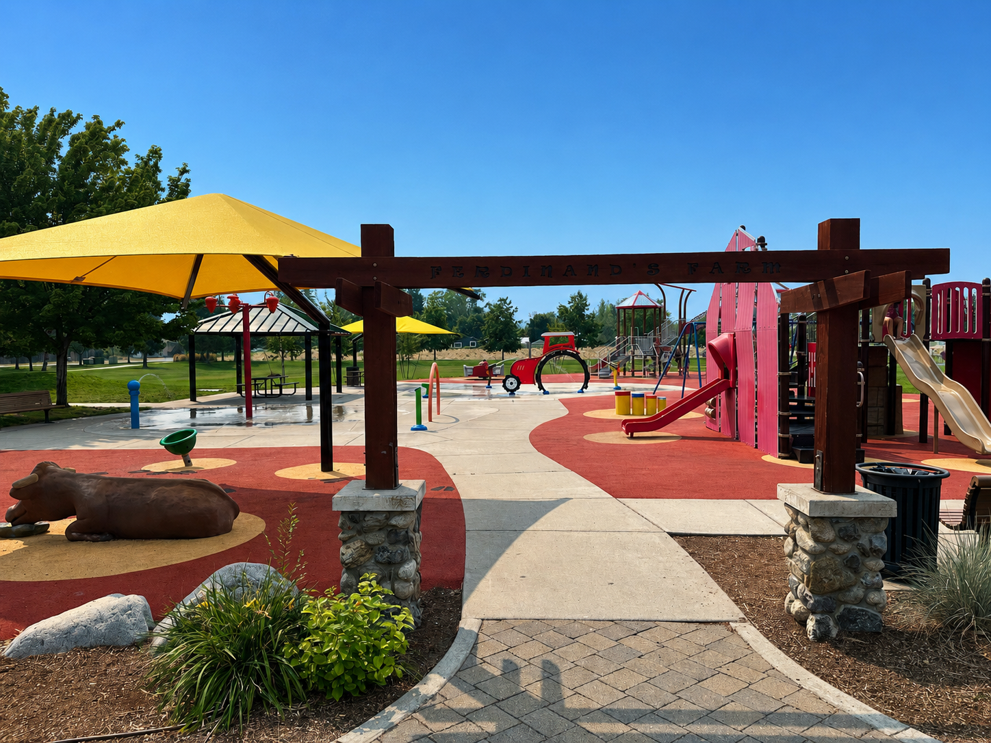 Colorful playground with yellow shade canopies and red play structures at Greenacres Park