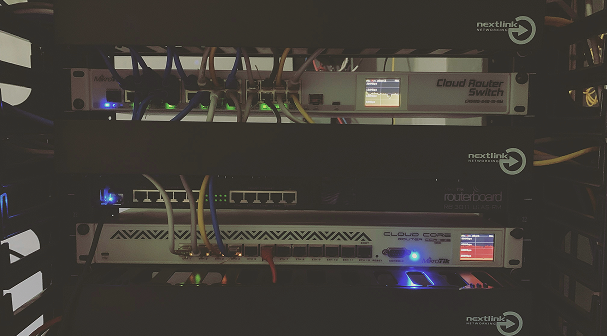 Rack-mounted network equipment with connected cables and active indicator lights.