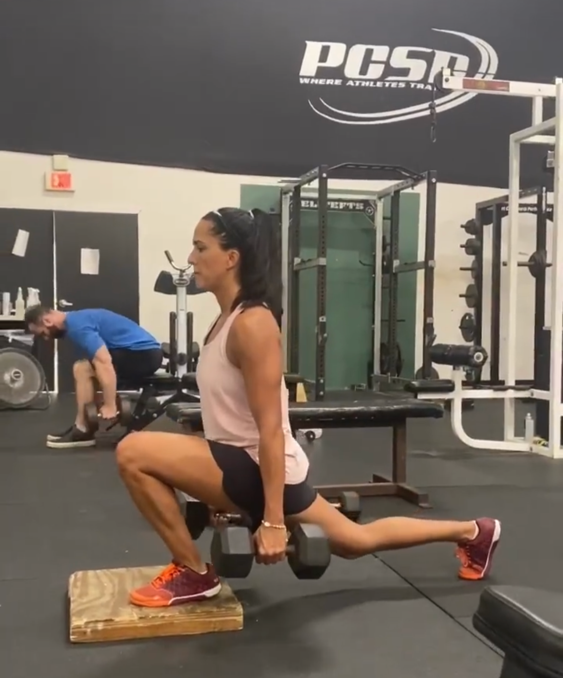 Nicole Bello client performing a dumbbell front lunge in the gym