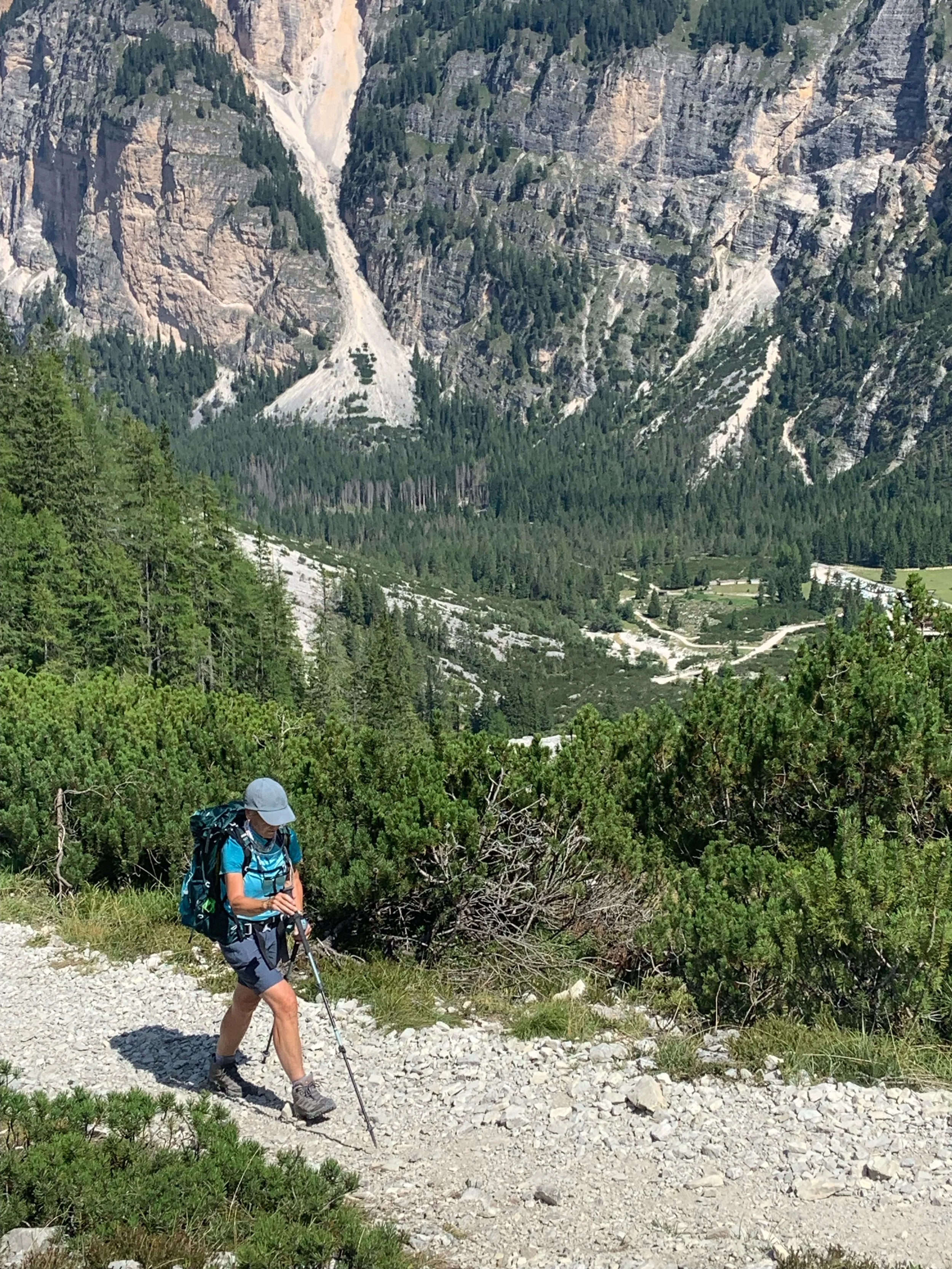 Nicole Bello client hiking a mountain trail with trekking poles