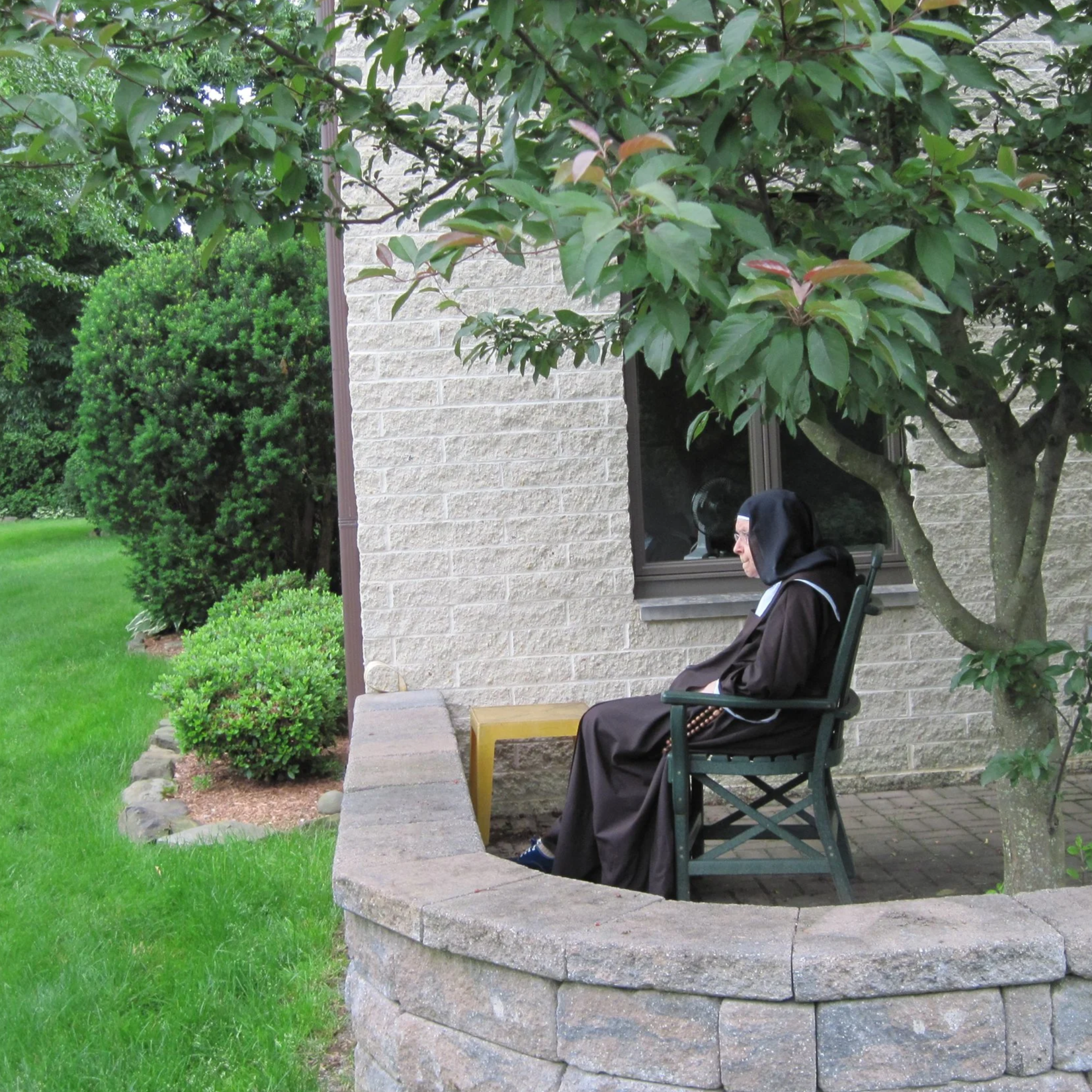 A Carmelite nun sits on a balcony in the cloister as she prays.