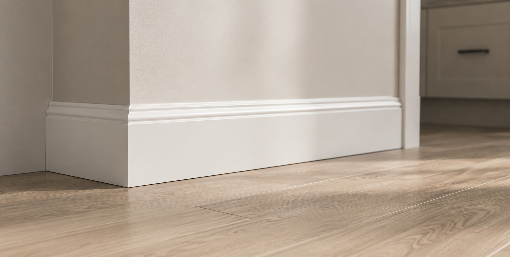 Interior baseboard and trim molding installation with finished wood flooring.