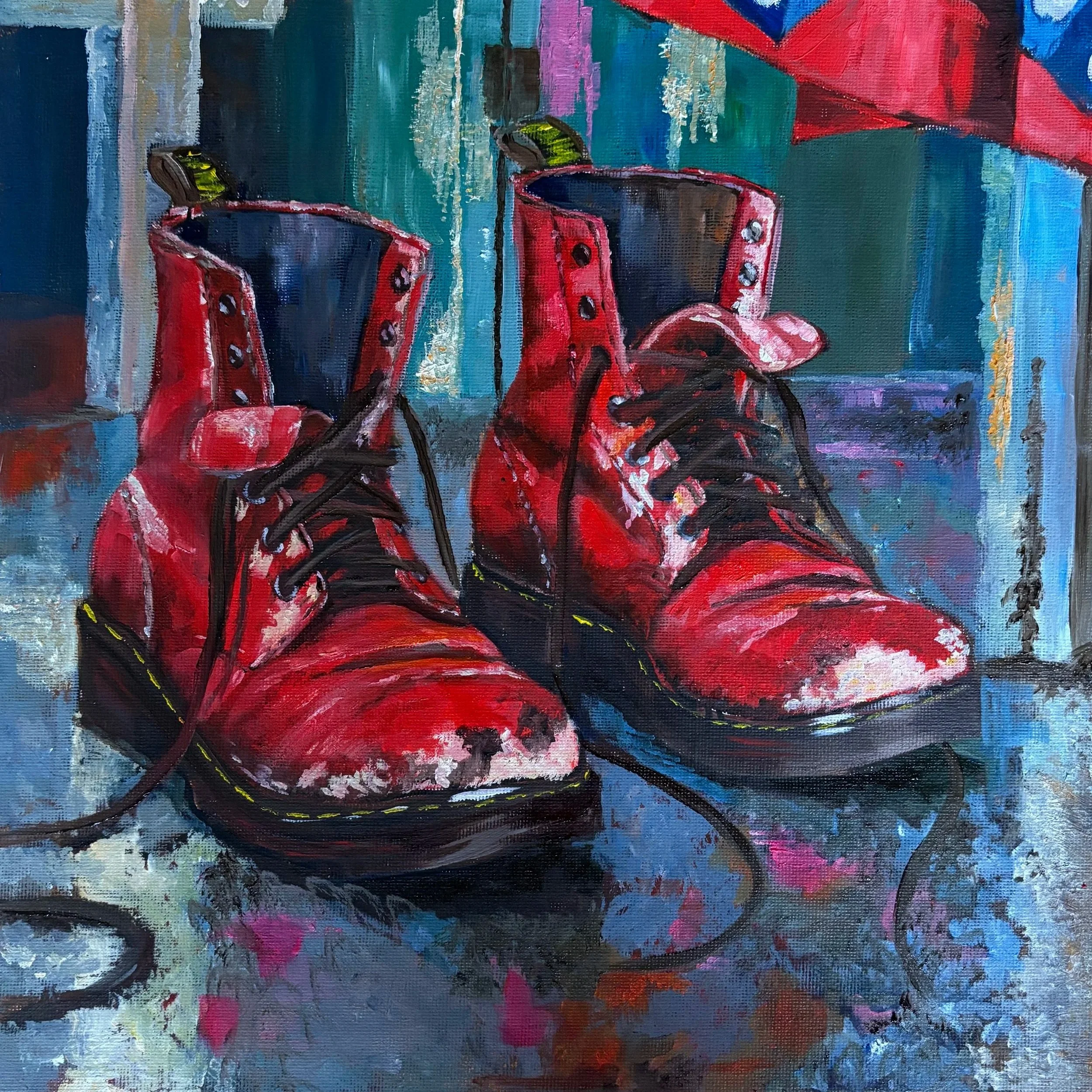 Painting of worn red lace-up boots with scuffed toes and loose black laces, reflected on a blue dressing-room floor beneath a colourful costume.