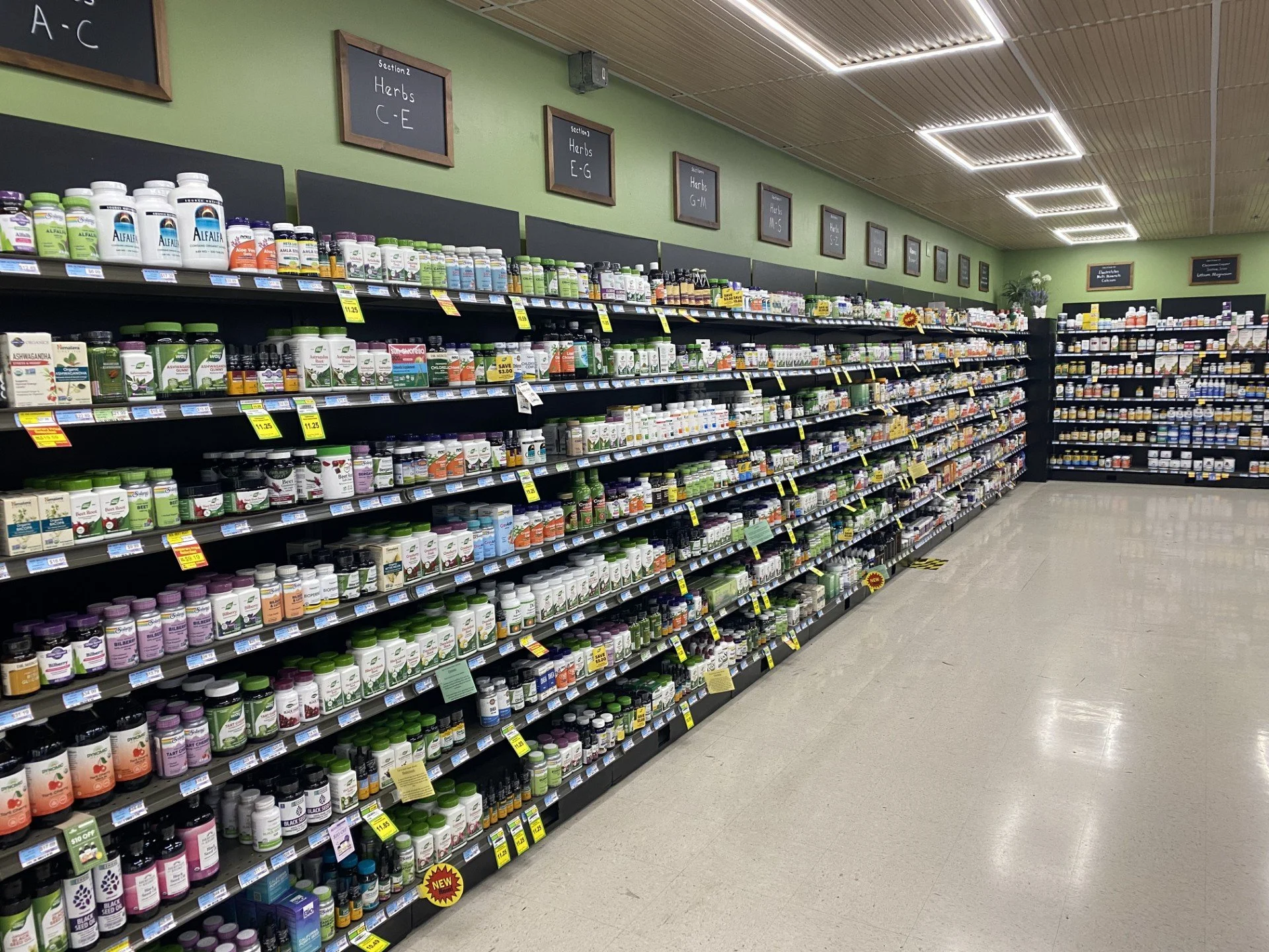 Health aisle at Andy's Market stocked with vitamin bottles and supplements.