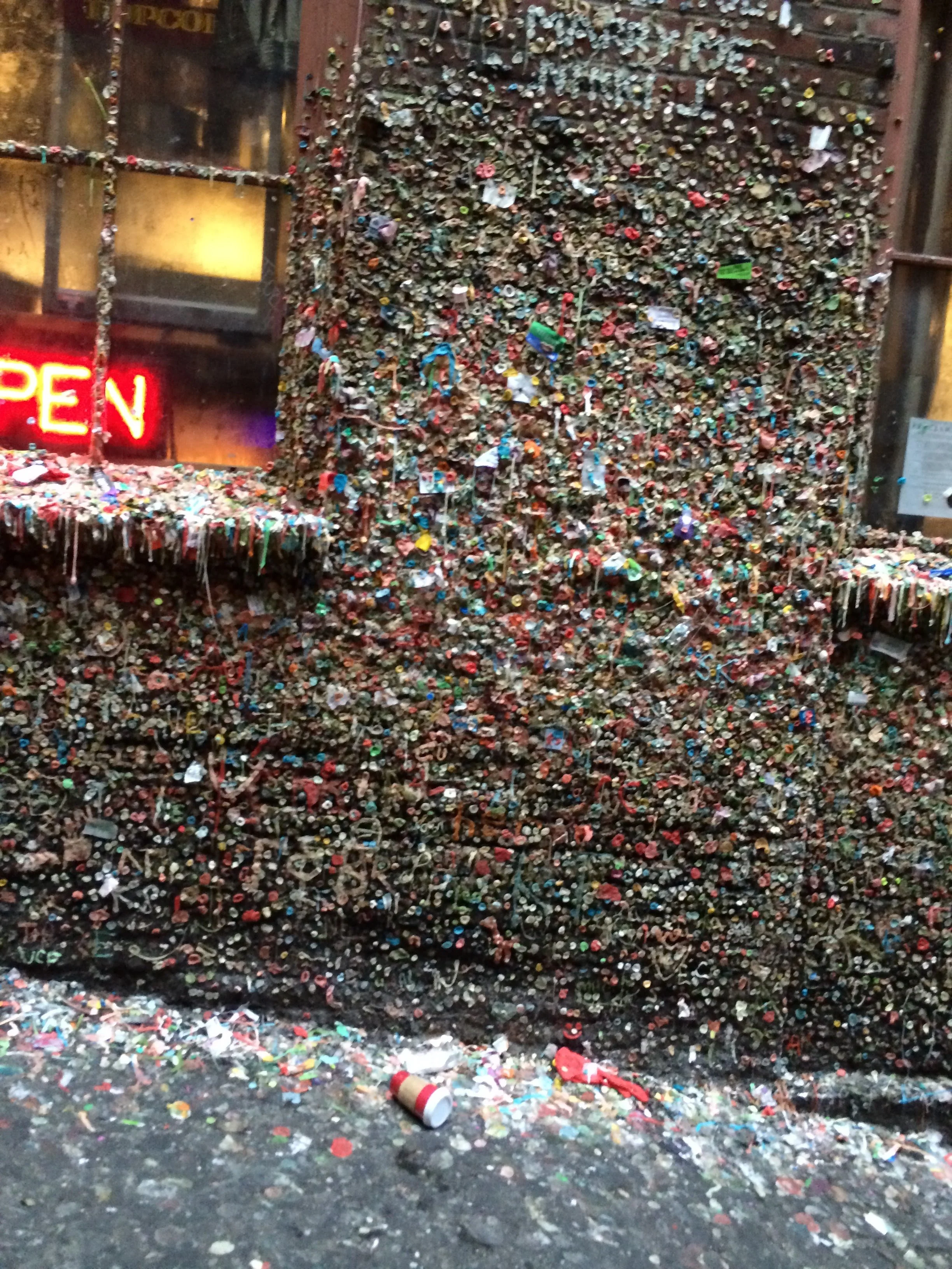 Brick alleyway in Post Alley covered in colorful chewed bubblegum at the Seattle Gum Wall for an Unsolicited Monologues commentary essay.