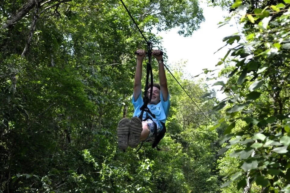 Traveler ziplining through a tropical forest
