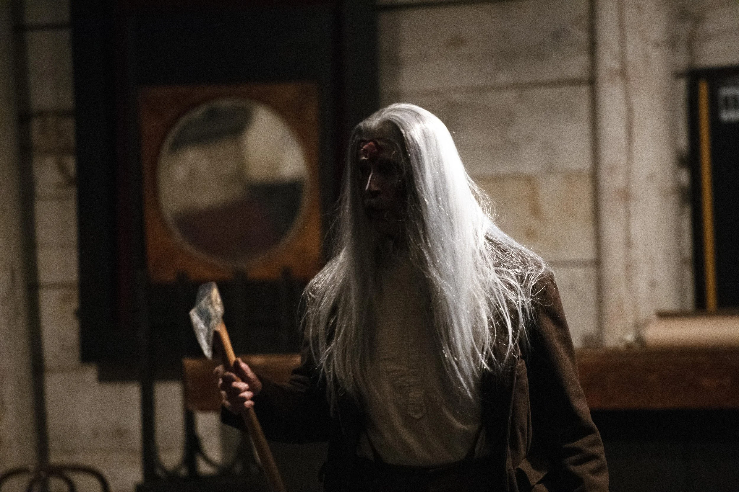 Frightening figure with long white hair holding an axe