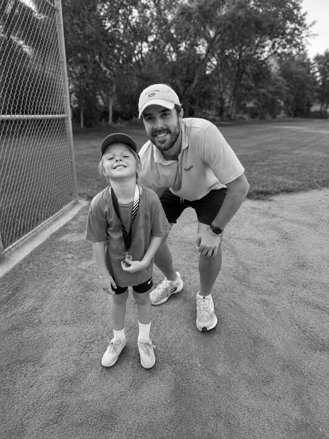 A father and son posing after dad's #1 job, coach.
