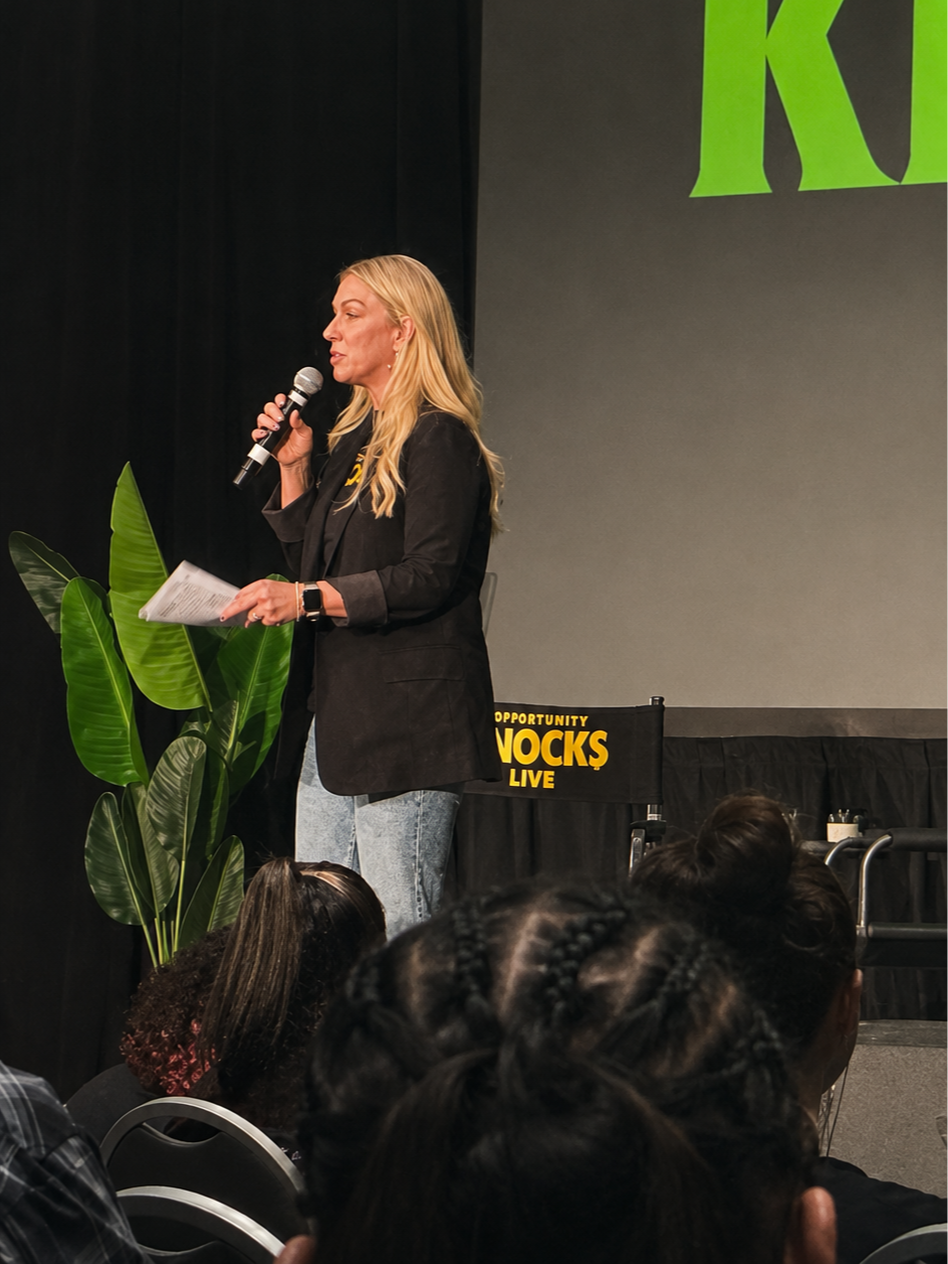 Angie Hughes speaking at Opportunity Knocks Live, an event she produced
