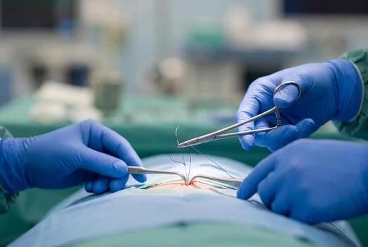 Surgeons performing an operation using surgical instruments in an operating room.