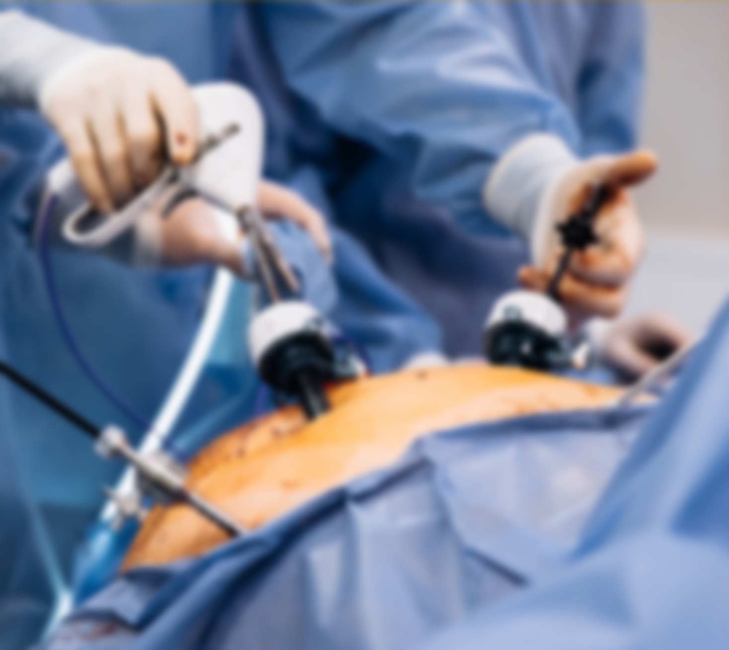 Surgeons wearing blue scrubs and gloves performing surgery in an operating room.