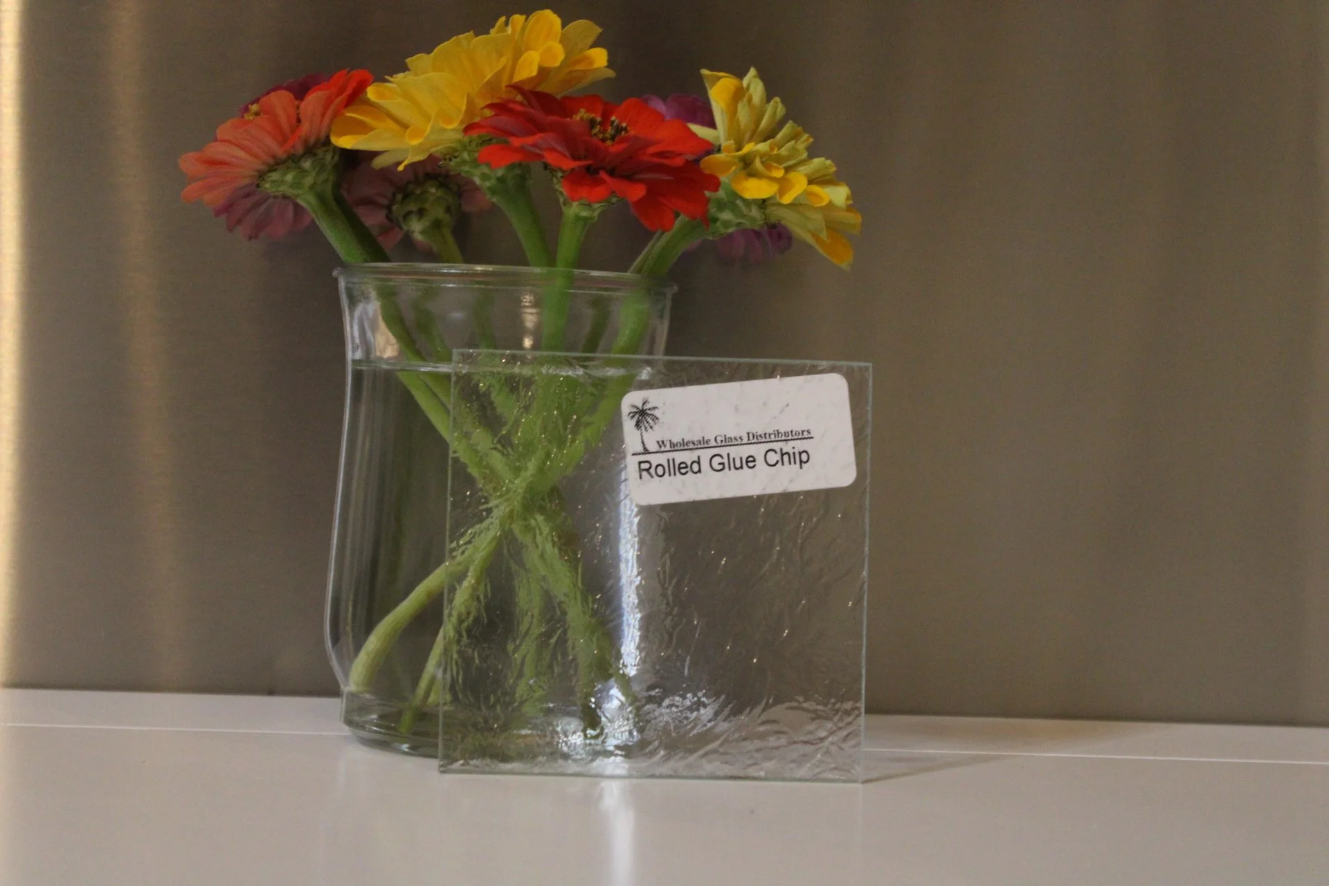 A bouquet of colorful flowers in a glass vase, with a label that reads "Rolled Glue Chip".