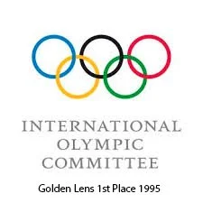 Olympic rings with text 'International Olympic Committee' and 'Golden Lens 1st Place 1995'.