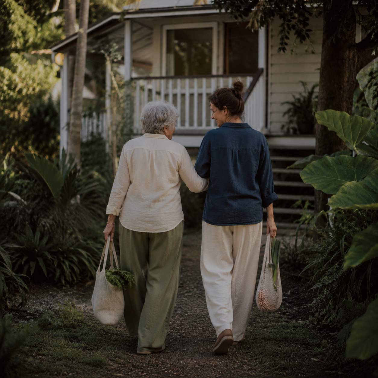 An Amitayus volunteer helping an older woman carry shopping home.
