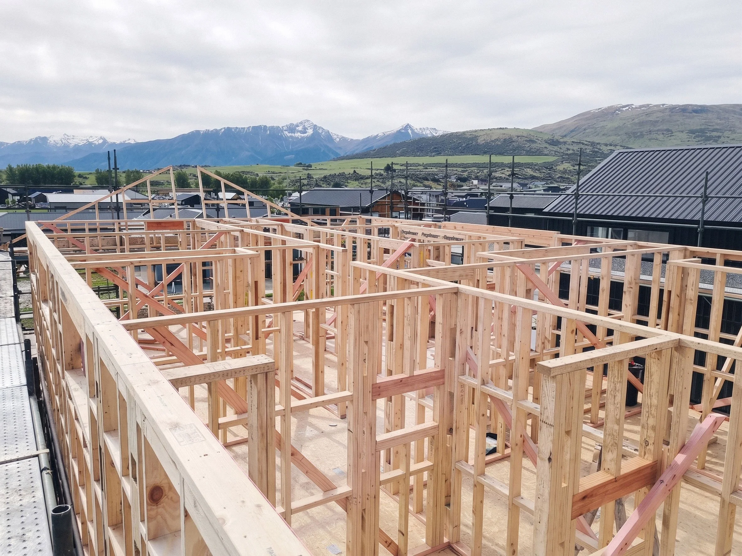 Timber framing under construction, with Ben Lomond mountain landscape in the background.