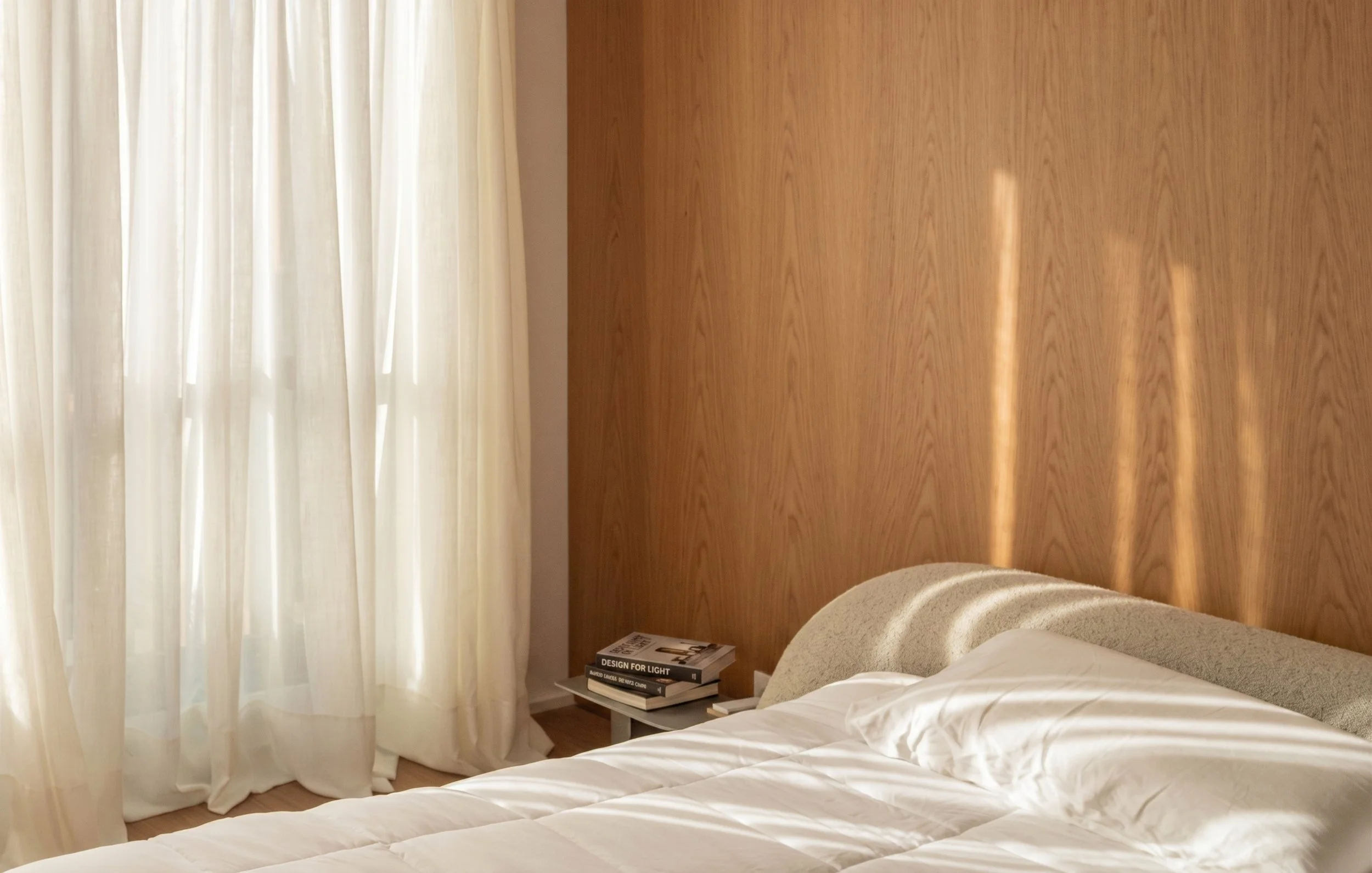 Bedroom with linen curtains, oak veneer headboard and white bedding.