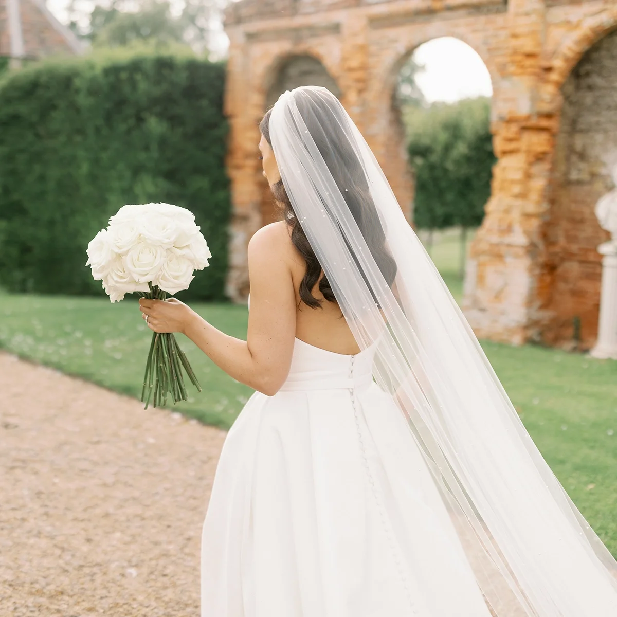 A bride walking through the gardens at Oxnead Hall in Norfolk