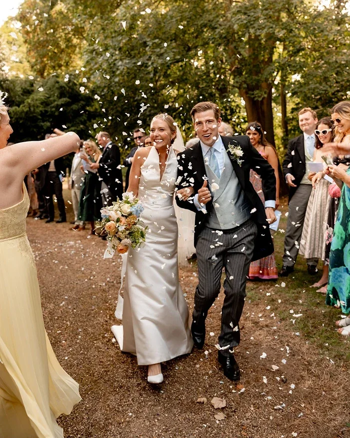 A bridal couple walking from their church wedding ceremony in Norfolk