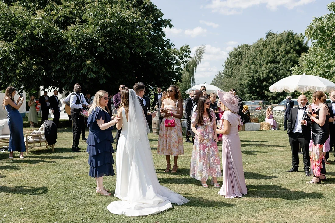 A garden wedding in Norfolk with guests and the bridal couple circulating among their guests