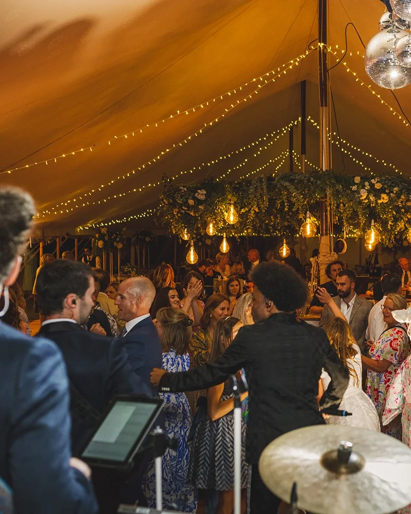 A band playing in a marquee with fairy lights for a party
