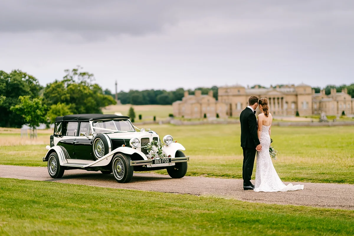 A bridal couple on their wedding day overlooking Holkham Hall in Norfolk