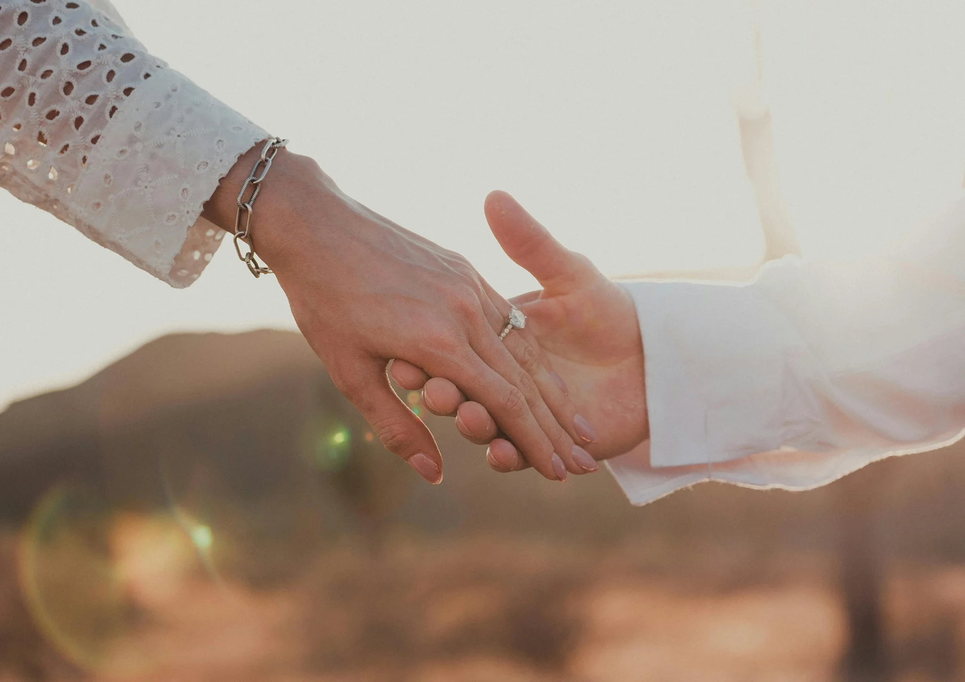 A couple holding hands after becoming engaged