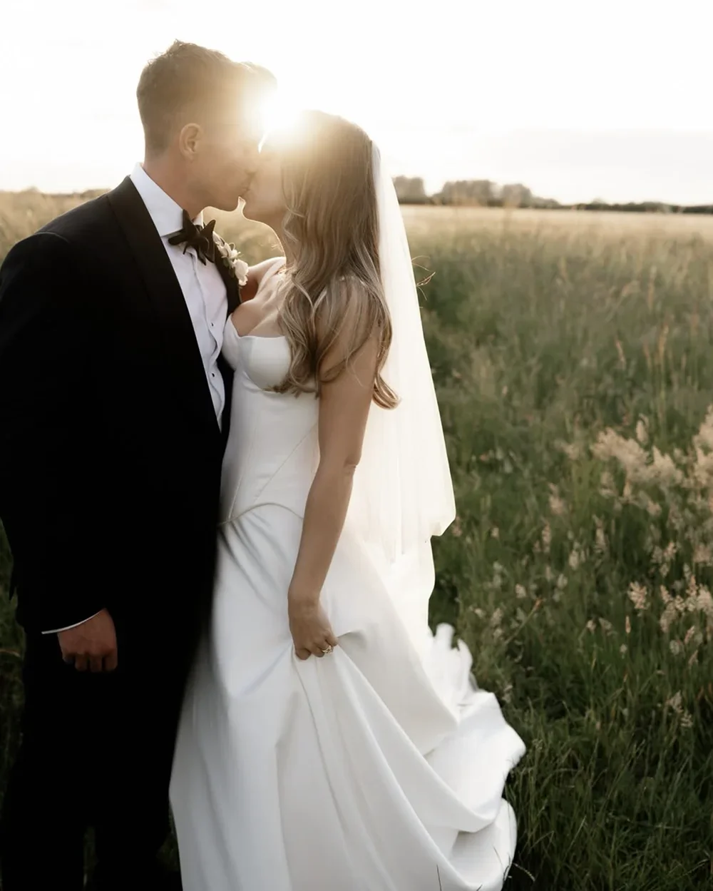 A newlywed couple photographed at golden hour in the Norfolk countryside