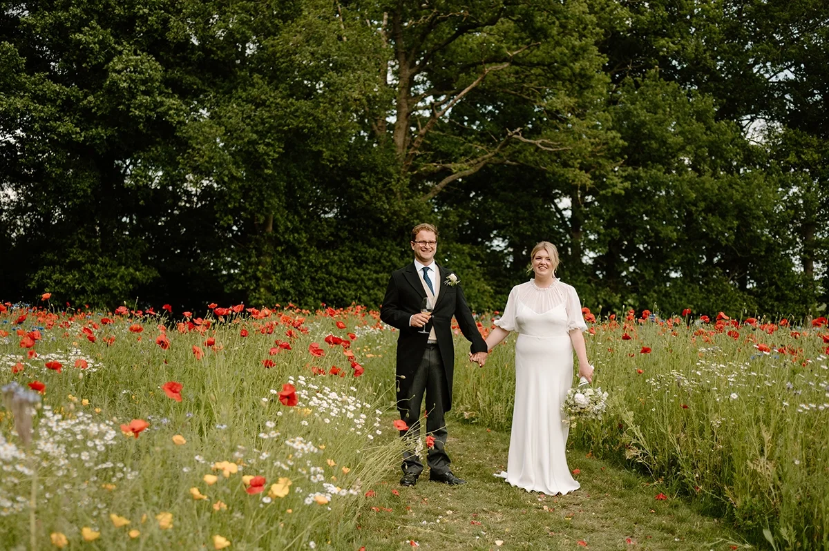 A bridal couple in a wildflower meadow after their wedding ceremony
