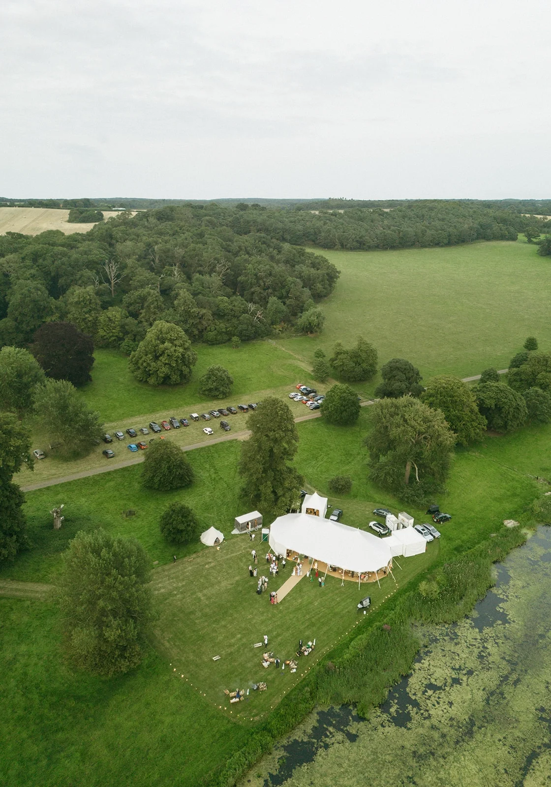 A marquee beside a lake in parkland surrounding a country house in North Norfolk