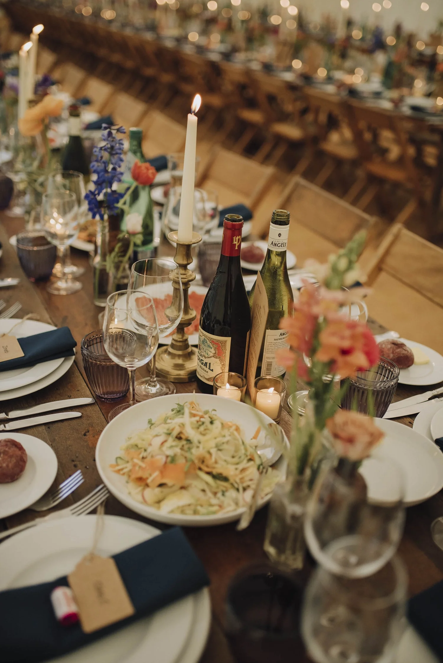 A marquee with rustic tables laid with sharing plates for a party