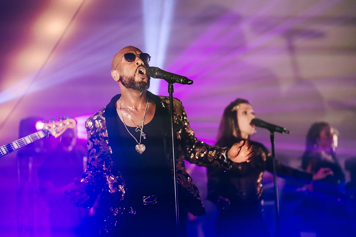 A band playing at a party in a marquee